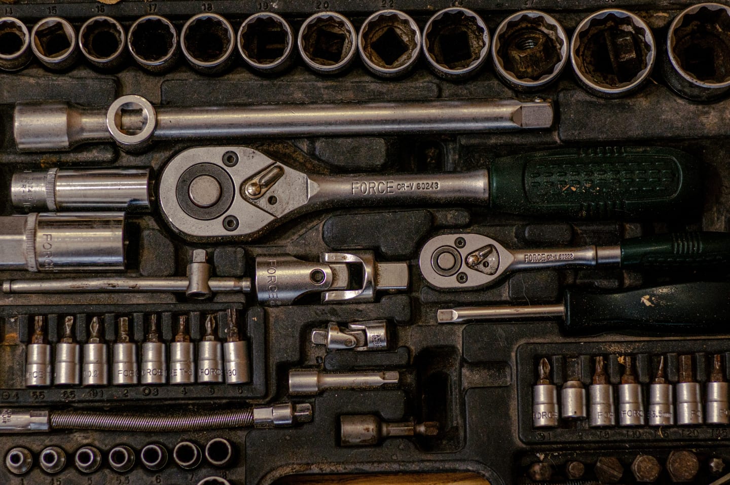 A ratchet set in its case, showing signs of age and rust.