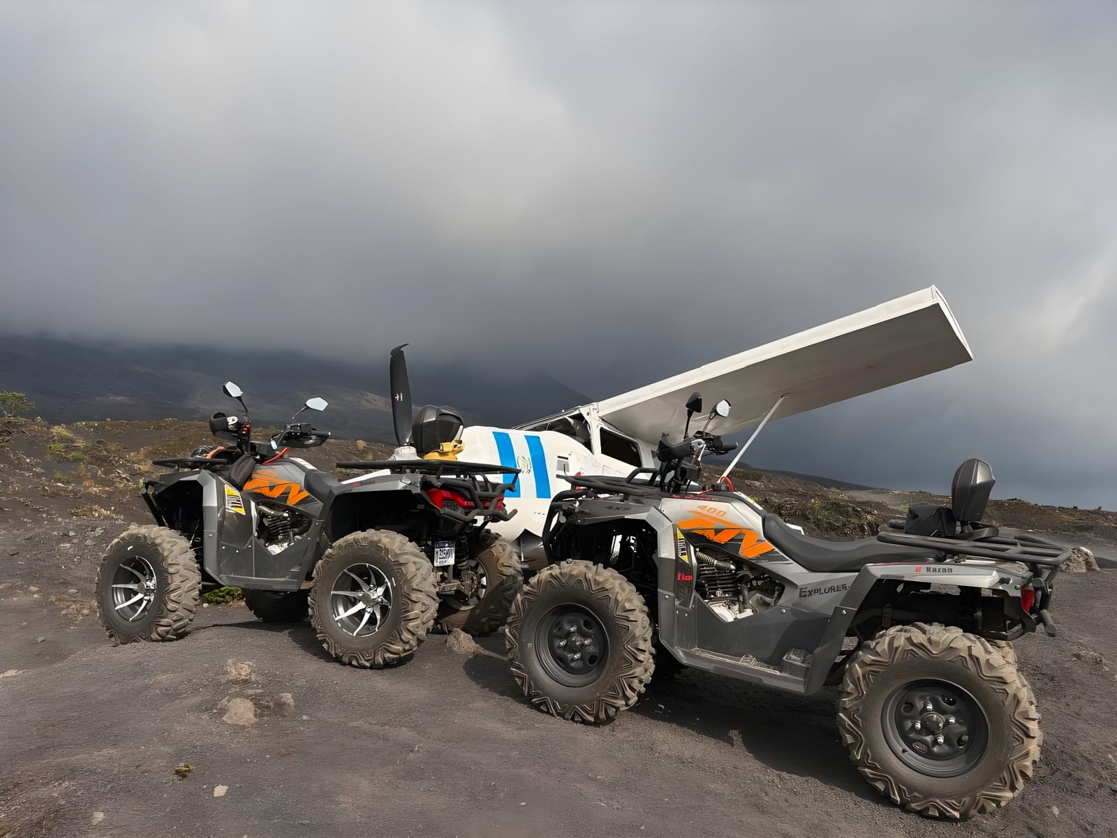 ATVs next to the small airplane on volcanic sand