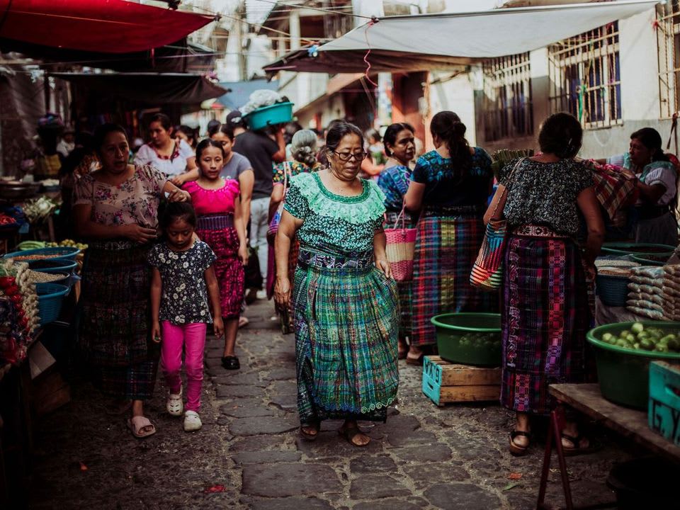 Mujeres con traje típico recorriendo el mercado
