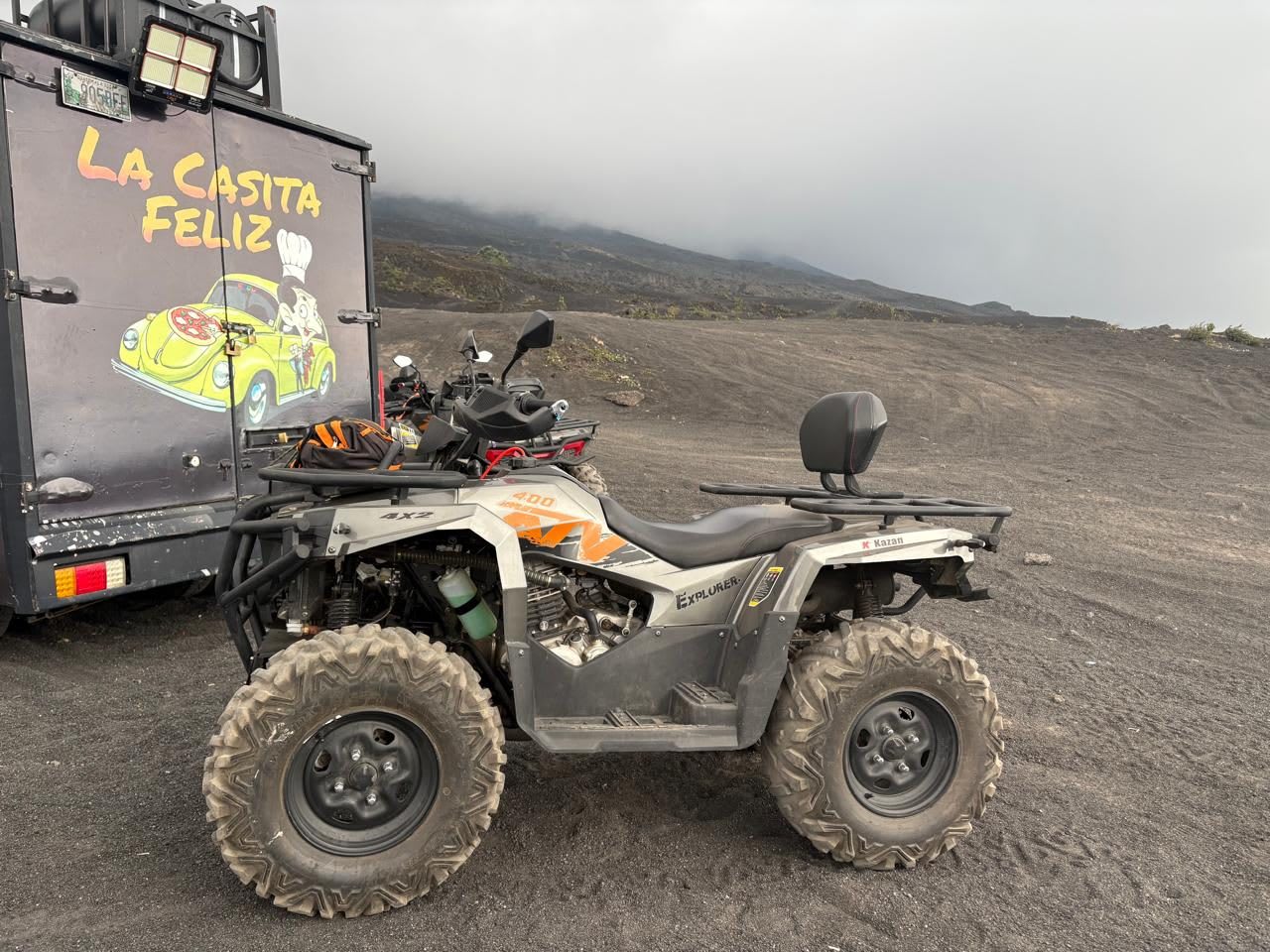 Cuatrimoto sobre arena volcánica bajo las nubes