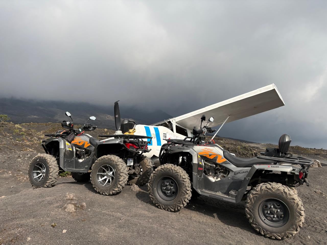 Cuatrimotos junto a la avioneta sobre la arena volcánica