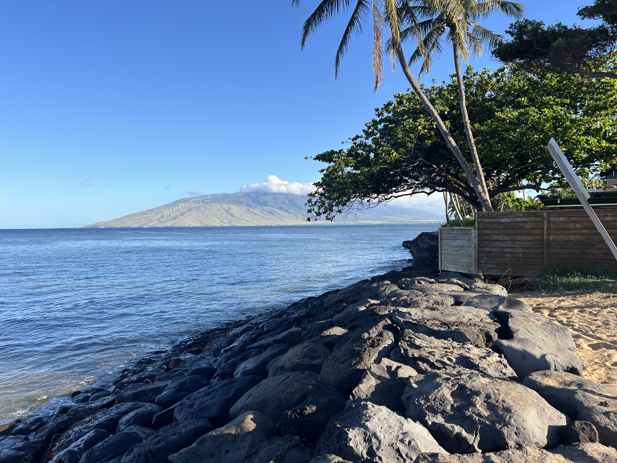 Lava rock coastline with West Maui mountains across the channel