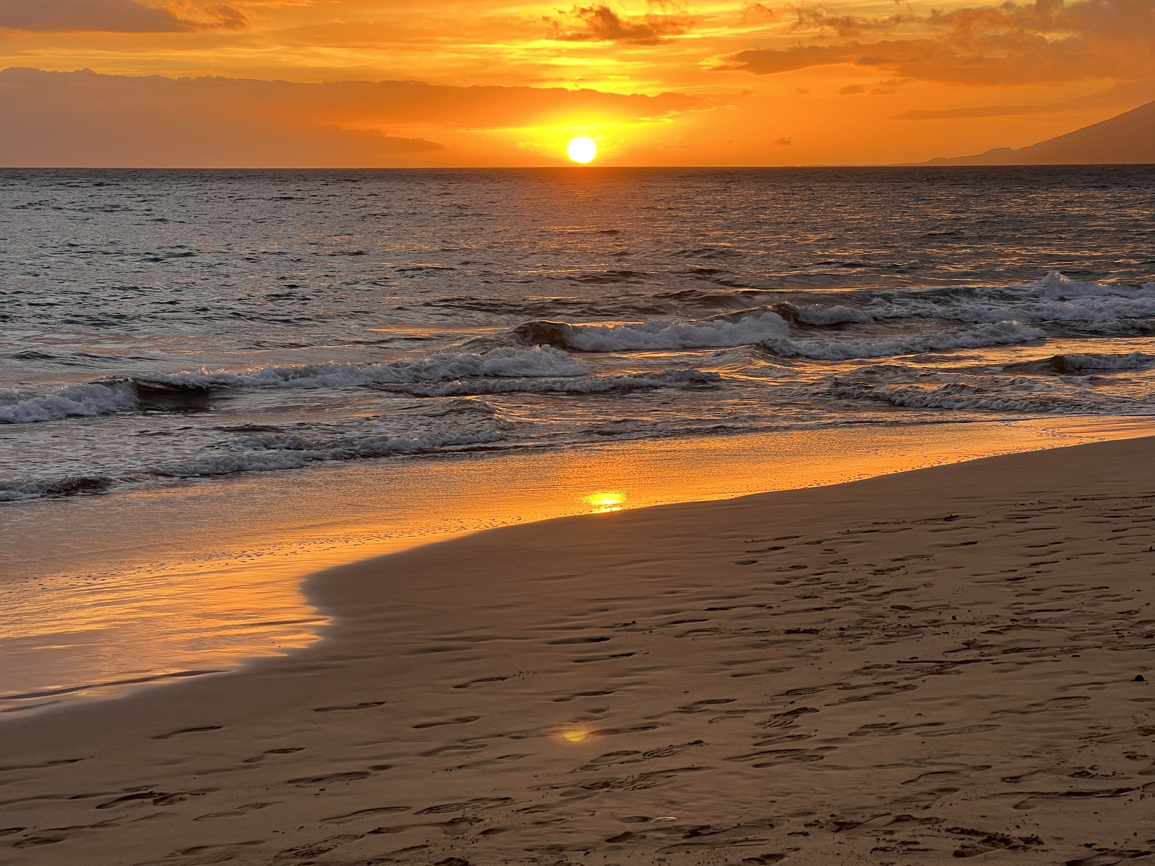 Kama'ole Beach at golden hour — wide view of the sunset crowd along the shore, June 29, 2026