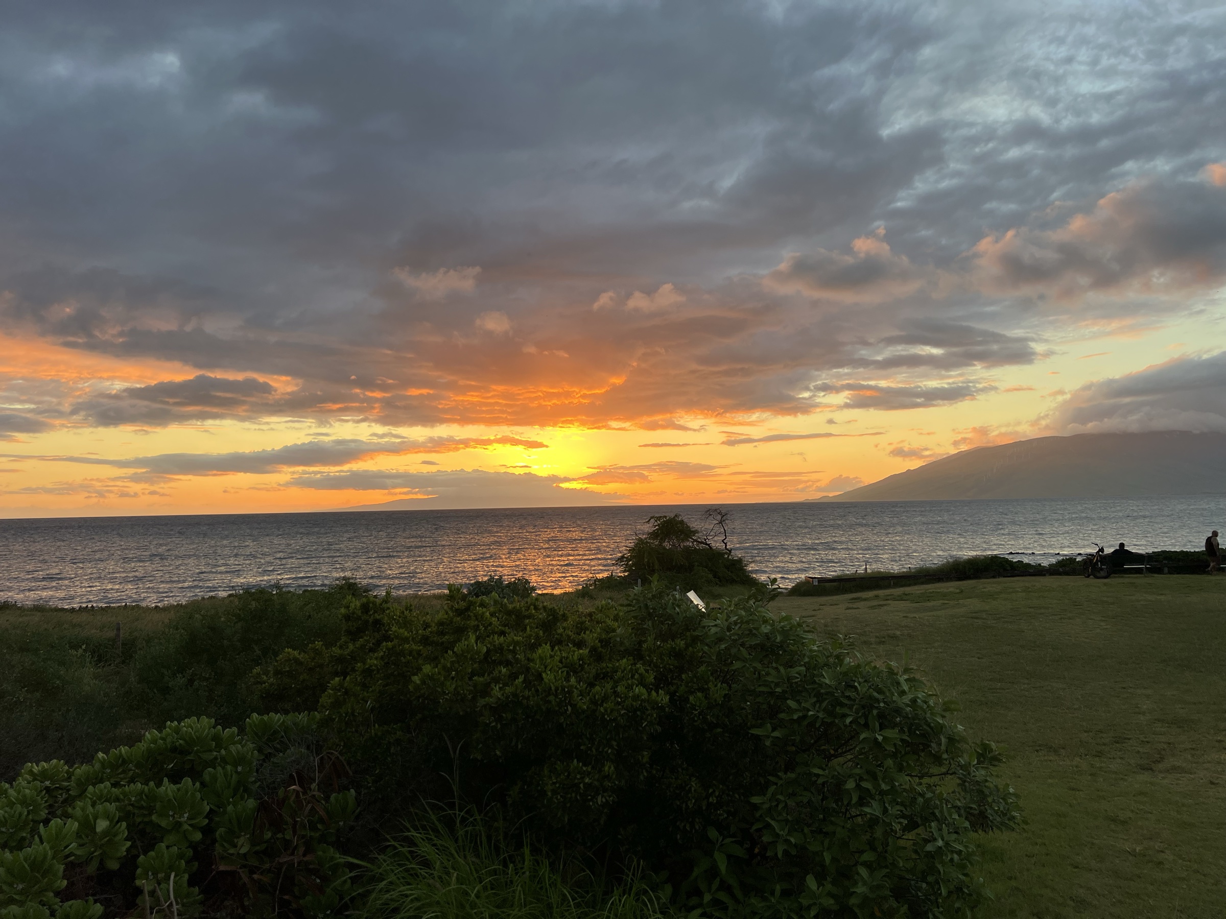 Kama'ole Park at sunset with naupaka foreground and West Maui mountains