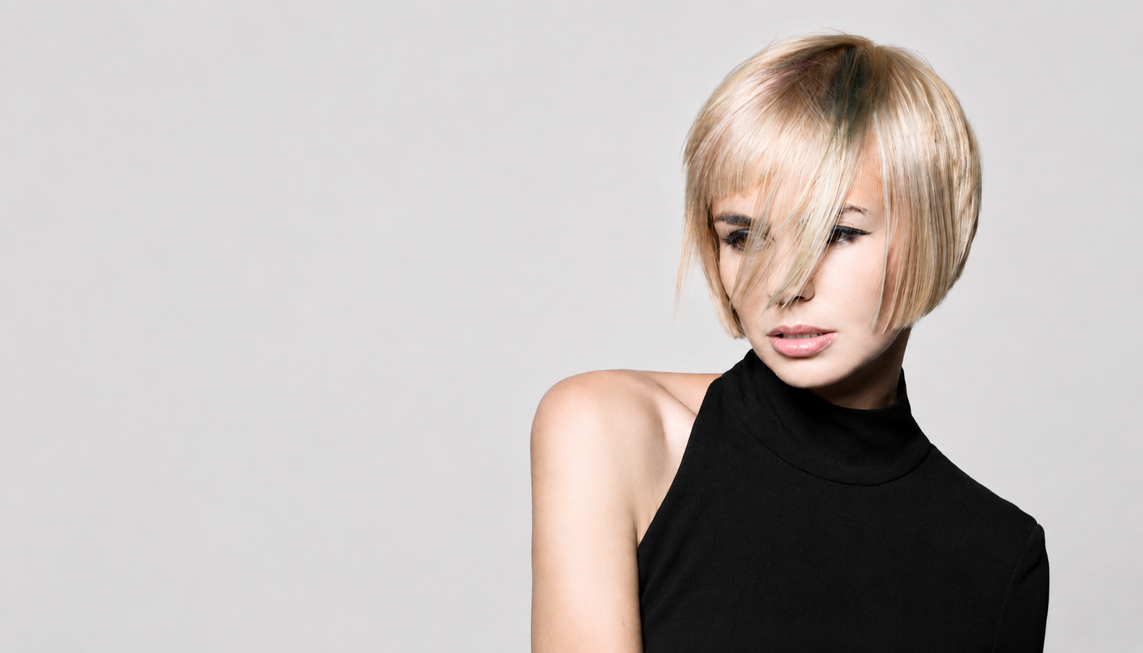 Professional blonde precision bob haircut with textured fringe and sleek salon finish.
