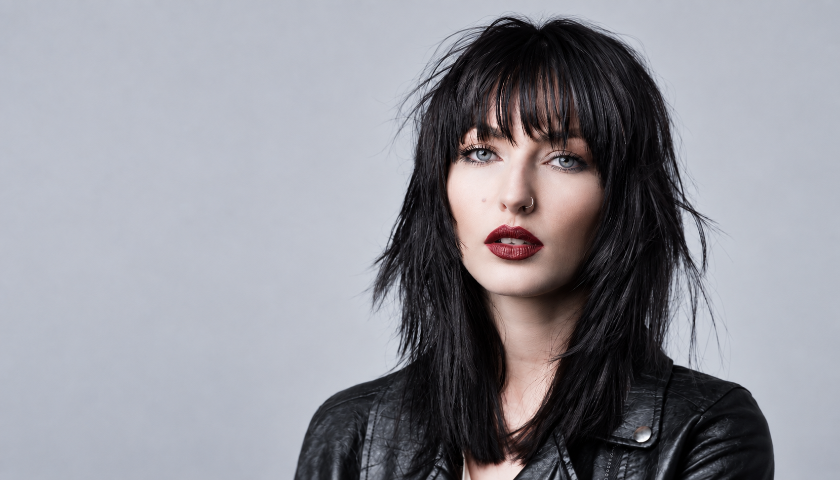 Modern women's haircut with dark layered hair, textured fringe and professional salon styling.