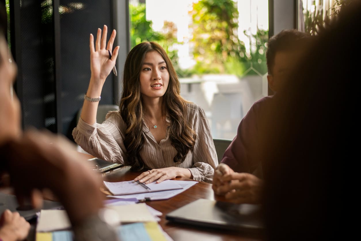 A student raising hand and asking a question about credit scores during a discussion