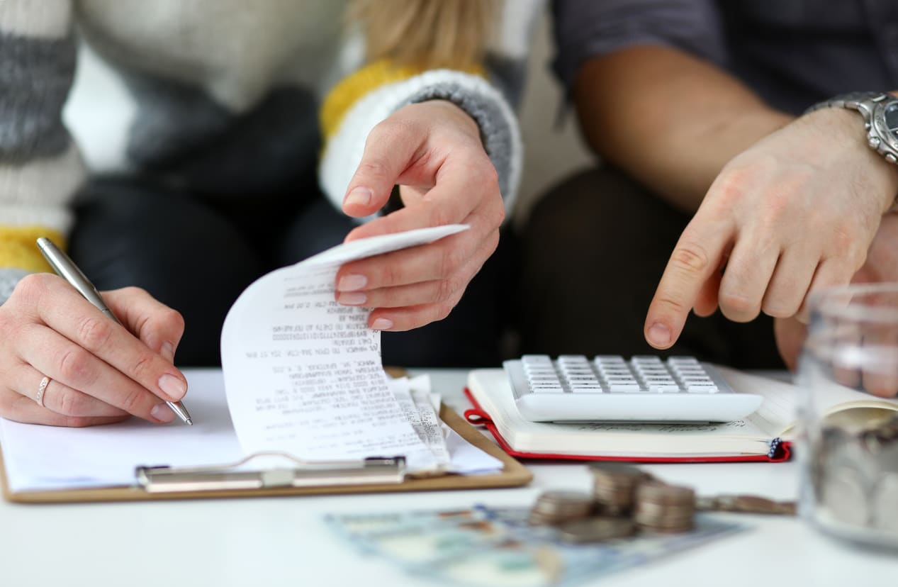 Close-up view of man and woman making account of family income.