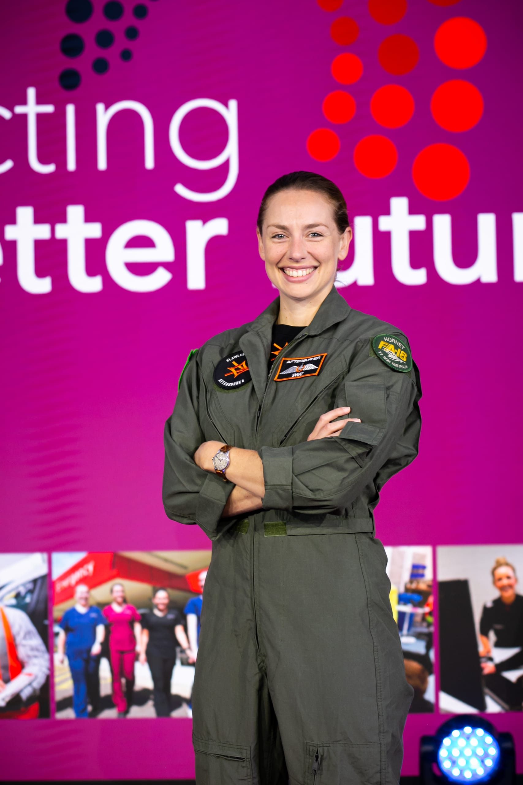 Female fighter pilot smiling on stage at an event