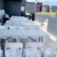 A plastic table and chairs are set up on a balcony.