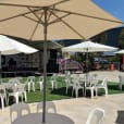 A round café table hire with tables and chairs and umbrellas.