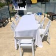 A white plastic table and chairs on a balcony.