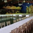 A timber trestle table, measuring 1.8m in length, set up in a large hall with a carousel for hire.