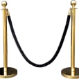 A pair of gold rope barriers with black velvet ropes.