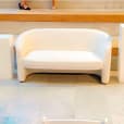 A white chair sits on top of a set of steps available for Bouclé 2 Seater Sofa Lounge Hire.