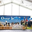 A large tent with people standing in front of it, adorned with a sleek Black Velvet Rope Hire.