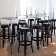 Black Ghost bar stools in the middle of a room available for hire.