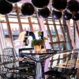 A table with black balloons in the middle of a room, enhanced by a Black Wire Stool.