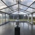 A clear tent with a chandelier in the middle, enhanced with Pkg 7 - 7 x Area Heater Hire w/ Gas Bottles.