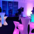 A group of colorful stools and tables in a tent available for Glow Pillar Hire.