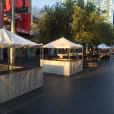 A vibrant city street adorned with numerous white tents offering fete stalls and tent hire, complete with convenient setup services.