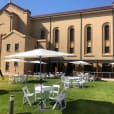 A large building with white tables and chairs in front of it, perfect for Market Umbrella Hire.