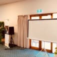 A green room equipped with a projector for hire.