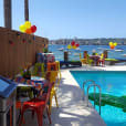 A lively pool party complete with a Jukebox & Karaoke Hire for added entertainment, where a table and chairs are conveniently placed near the water.