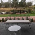 A table on a patio with a view of a pond.