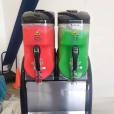 Two soda dispensers sitting on top of a table, offering a variety of drinks with Slushie Machine Hire: Pkg 4 - serving up to 180 Drinks.