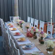 A tea party set up with a white tablecloth on a large trestle table.