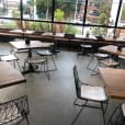 An empty restaurant with Black Wire Chairs and tables.