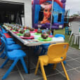 An enchanting table set up for a child's birthday party, complete with vibrant Kids Chair Hire options.