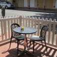 A table and chairs on a balcony with a white picket fence.