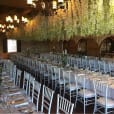 A white Tiffany chair hire room with flowers hanging from the ceiling.