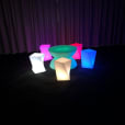 A group of vibrant stools in front of a curtain, available for hire.