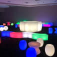 A room full of colorful glow stools and tables for hire.