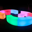 A set of colorful Glow Benches in a dark room.