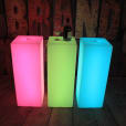 Three lighted cubes, with a glowing effect, placed on a wooden floor.
