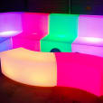 A Glow Lounge Suite Hire in a dark room set with colorful LED sofas.