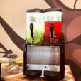 Two drinks are sitting on top of a table, prepared from Slushie Machine Hire: Pkg 4 with a total of approximately 180 drinks served.