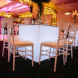 A square table and chairs in a room with glowing lights.