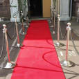 A red carpet leading up to a doorway, with chrome bollards hire adding an elegant touch.