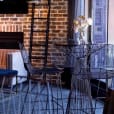 A room with a table and chairs in front of a fireplace, featuring Black Arrow Stool Hire.