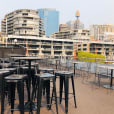 A rooftop bar in Sydney with a view of the city, offering Black Tolix Stool Hire.