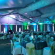 A large tent with green and blue Par Can lighting.