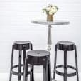 Three black Ghost stools on a white table.