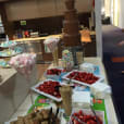 A chocolate bar with strawberries and other desserts on a table, showcasing the abundance of Strawberries 1kg.