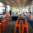 A room full of orange Tolix stools for hire.