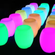 A group of colorful glow stools in a dark room.